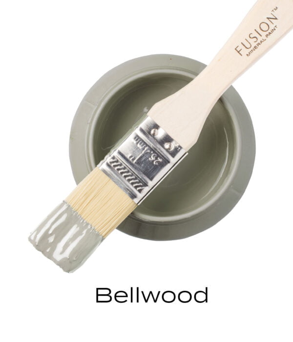 An angled brush that has been dipped in, and then placed on top of an open pint of Bellwood Fusion mineral paint to indicate the colour.