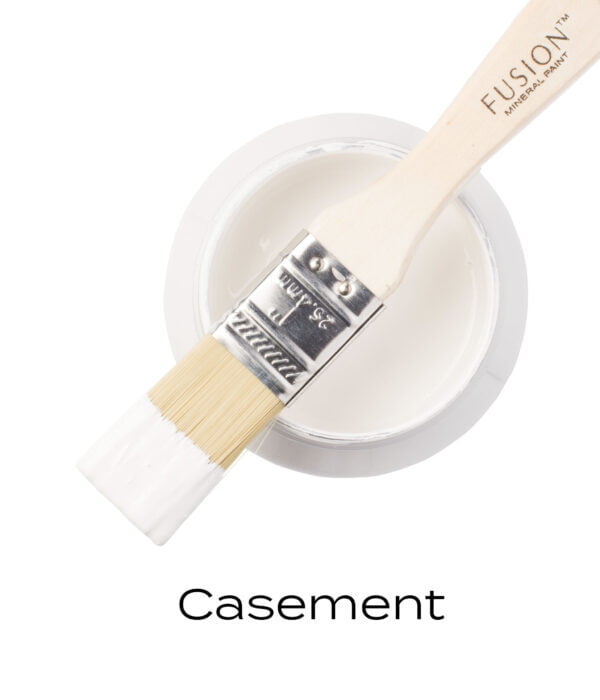 An angled brush that has been dipped in, and then placed on top of an open pint of Casement Fusion mineral paint to indicate the colour.