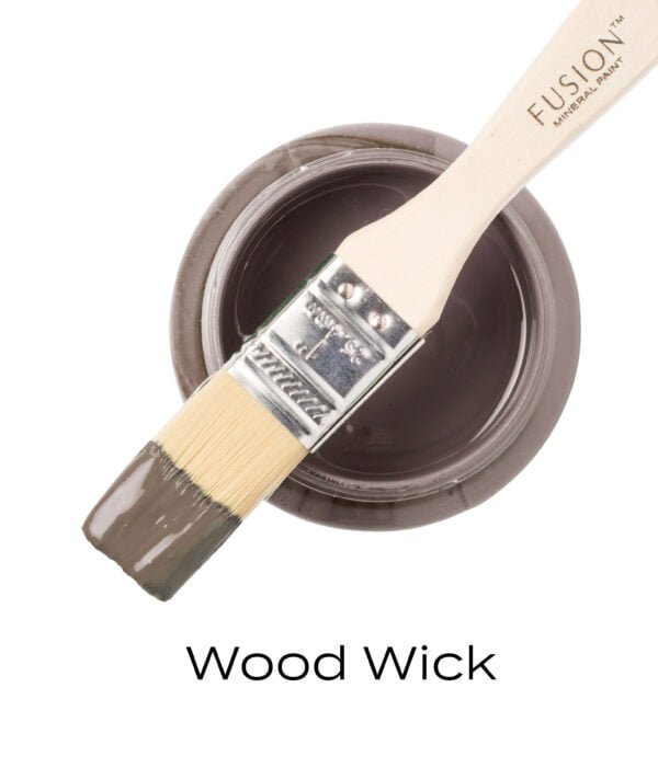 An angled brush that has been dipped in, and then placed on top of an open pint of Woodwick Fusion mineral paint to indicate the colour.