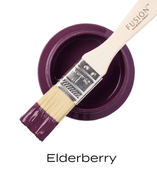 An angled brush that has been dipped in, and then placed on top of an open pint of Elderberry Fusion mineral paint to indicate the colour.