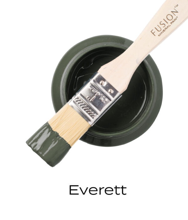 An angled brush that has been dipped in, and then placed on top of an open pint of Everett Fusion mineral paint to indicate the colour.