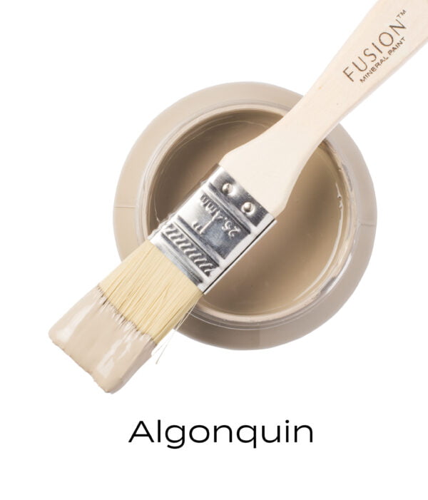 An angled brush that has been dipped in, and then placed on top of an open pint of Algonquin Fusion mineral paint to indicate the colour.